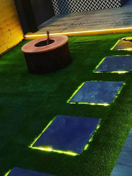 A close-up of the backlit stone pathway. The light escaping from the edges of the stones creates a magical, floating effect at night.