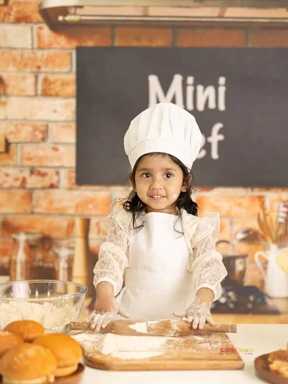 Welcome to the mini chef's kitchen! I love bringing imaginative themes to life, and this little baker, complete with a chef's hat and flour on her hands, makes for an incredibly fun and unique toddler photoshoot.