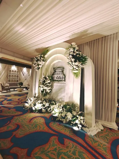 A beautiful floral photo-op archway with a custom sign, providing a dedicated and well-lit space for guests to take pictures and create lasting memories of the event.