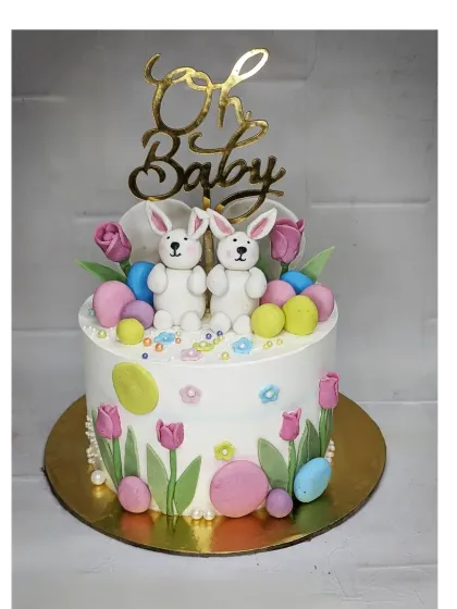 An "Oh Baby" baby shower cake with a choco-vanilla flavor. This design is inspired by Pinterest and features cute fondant bunnies and Easter eggs.