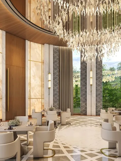 The grand banquet hall at the House of Abhinandan Lodha's prestigious clubhouse in Alibaug. The circular room features soaring ceilings, a magnificent crystal chandelier, and floor-to-ceiling windows overlooking the lush landscape.
