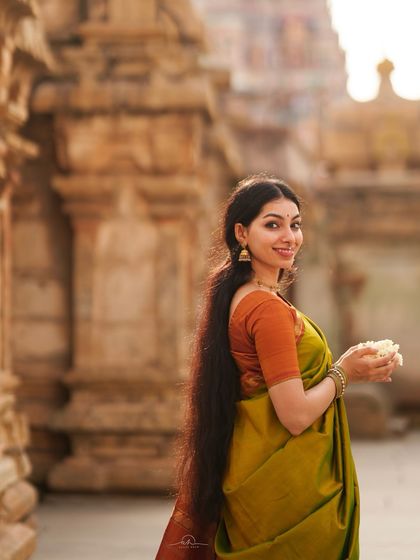 A classic portrait taken at a temple, embodying the concept of śṛṅgāra or divine love. The traditional saree and setting work together to create an image of grace and timeless beauty.