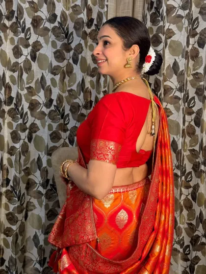 This view highlights the elegant back blouse design and the traditional hairstyle. The makeup ensures a flawless look from every angle, perfect for photographs.