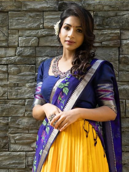 The full ensemble, showing the beautiful contrast between the bright yellow skirt and the deep blue blouse and dupatta.