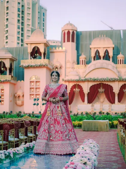 The bride stands on the aisle of her palace-themed wedding venue, looking like royalty.