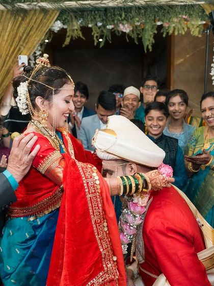 The groom seeks blessings in a traditional Maharashtrian wedding. We love capturing these moments of respect and family connection.