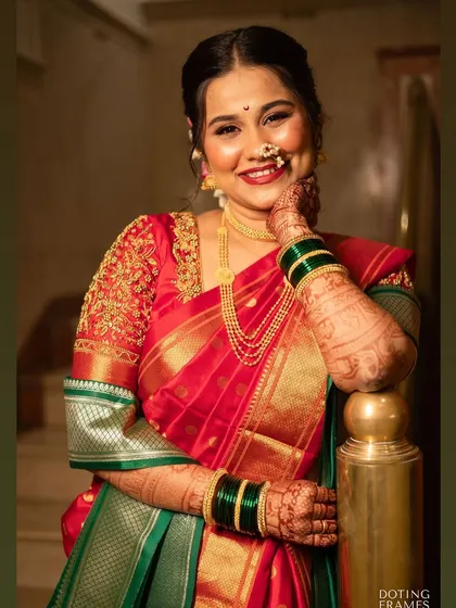 A happy, relaxed bride in a traditional red and green Nauvari saree. Her smile is the best accessory.