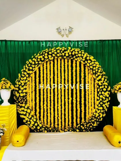 A classic Haldi ceremony setup, vibrant with traditional marigold flower arrangements against a rich green backdrop. This design brings out the joyful and sacred feeling of the 'sambharama'.
