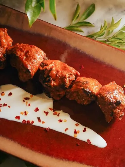 A top-down view of the Chicken Banjara Tikka, showing the sprinkle of chili flakes on the sauce. It's these small details that elevate a simple dish into a gourmet experience.