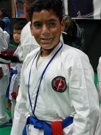 A happy and proud moment for one of our young competitors, wearing his medal after a tough bout. His smile shows the satisfaction of giving his best.
