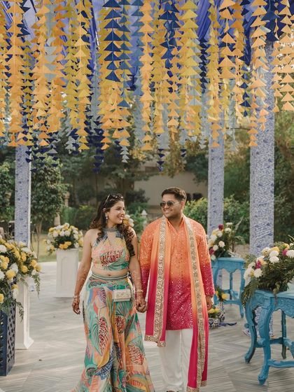 Another shot of the happy couple under the colorful tassel ceiling, capturing the fun and festive spirit of their Haldi celebration.