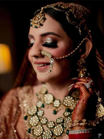 A close-up on the bride's sparkling eyes and the equally sparkling nath and necklace.