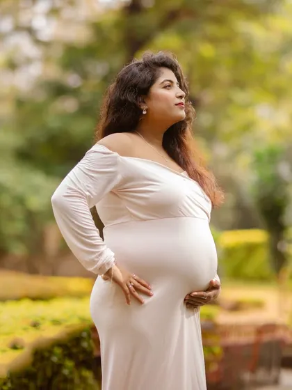 A serene solo portrait of a mother-to-be, cradling her bump in a beautiful garden. I use soft, natural light to emphasize the glow and beauty of pregnancy.