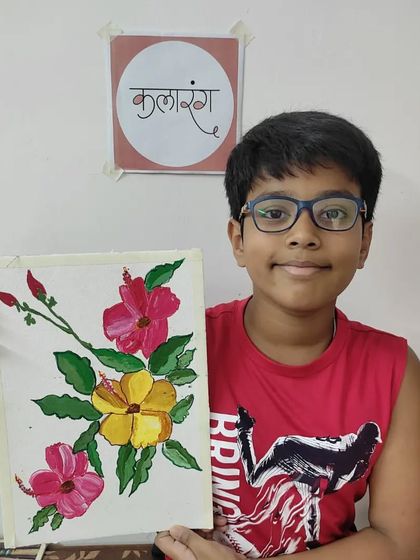 A student proudly holds up his detailed floral painting. This piece shows a great understanding of composition and color, skills we develop during our art camps.