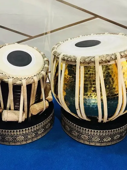 This is our handcrafted brass designer tabla set, featuring a 3kg dagga (left drum) and a D-scale tabla. The hammered pittal finish and professional quality rings make it a stunning instrument for both its sound and appearance.