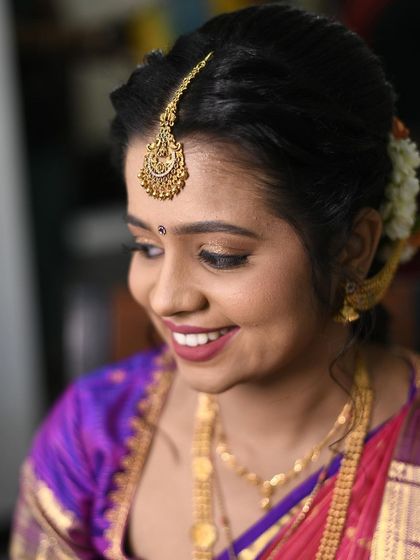 A sweet and traditional look for an engagement. The makeup is soft and pretty, paired with a classic bun adorned with jasmine flowers and a beautiful maang tikka.