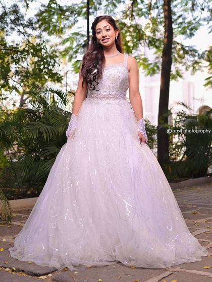 A full view of this sparkling white wedding gown. The voluminous skirt and glittering details make it a perfect choice for a fairytale church ceremony.