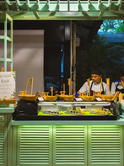 Our vibrant Sushi Bar setup, featuring sushi boats and a chef ready to serve fresh rolls.