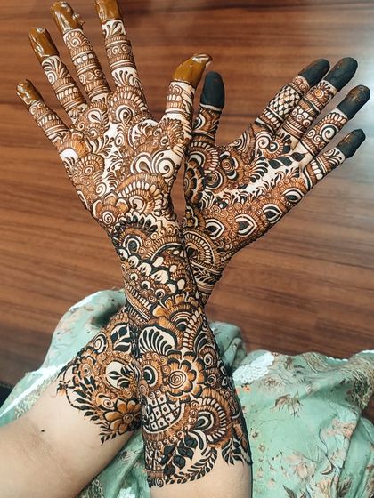 A final look at this beautiful, full-coverage bridal henna. The dark, solid fingertips provide a classic finish to the incredibly detailed work on the hands and arms.