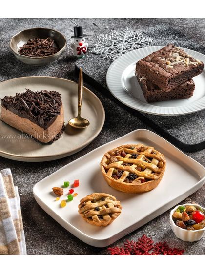 An assortment of desserts including a chocolate mousse slice and apple tarts, showcasing a variety of bakery offerings.