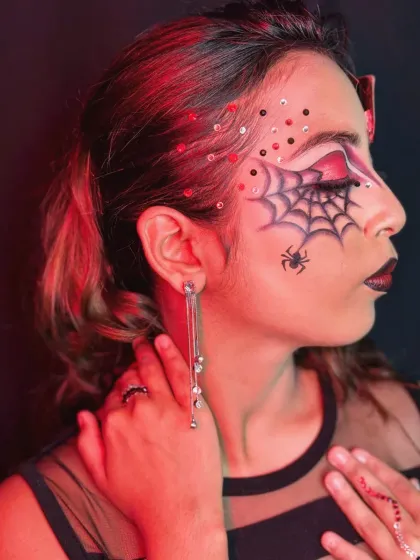 A side profile of the 'Queen of Hearts' look, showing the intricate spiderweb detail and the careful placement of sequins.