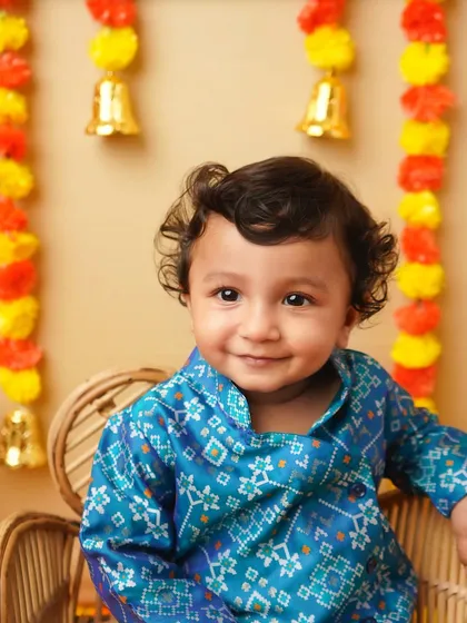 A close-up portrait of the smiling boy in his festive attire. His happy expression perfectly captures the joy of the festival.