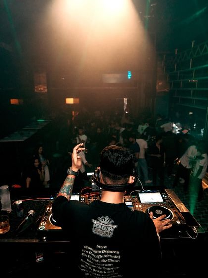 A view from behind the decks, looking out at a full house. The single spotlight highlights my position as the conductor of the night's energy.
