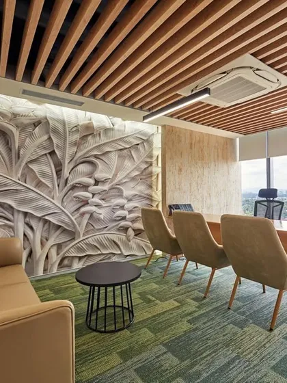 The boss's cabin features a stunning 3D-carved wall panel with a botanical leaf motif. The wood-slat ceiling and views of the green landscape outside further enhance the natural feel.