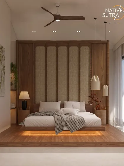 A sanctuary designed to soothe. This master bedroom blends Japandi minimalism with rich natural textures, elevated on a warm wooden platform with integrated lighting. The cane-panelled headboard and layered lighting create a space where every detail whispers calm, embodying our philosophy of warm minimalism and zen living.