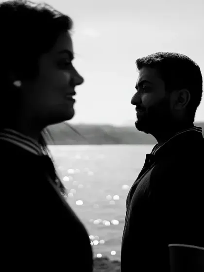 A moody black and white silhouette of the couple by the water. The focus on their profiles creates a sense of quiet contemplation and deep connection.
