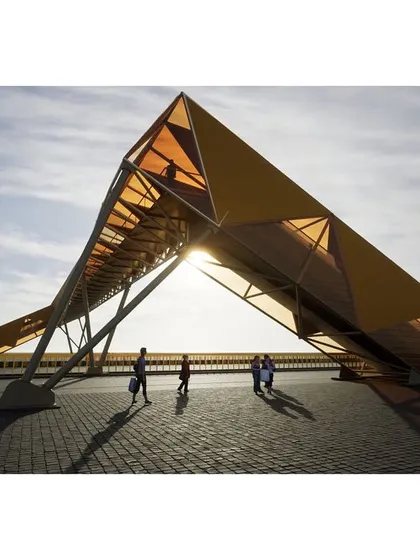 This render shows the pedestrian footbridge at sunset. The sculptural form of the bridge is designed to be a landmark, an piece of urban art that is also a functional piece of infrastructure.