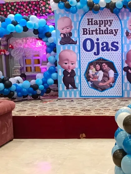 Who's the boss? Your little one is. Our Boss Baby theme is perfect for a first birthday, featuring a custom backdrop with the birthday boy's name and photo, surrounded by a stylish blue, black, and white balloon arch.