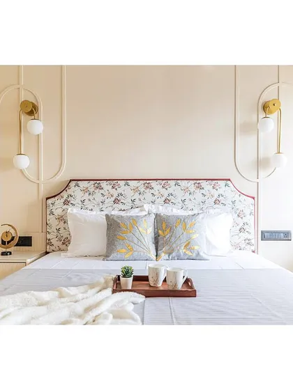 The symmetrical design features custom pendant lights on either side of the bed, adding a modern and elegant touch. The embroidered cushions bring in texture and a hint of luxury.