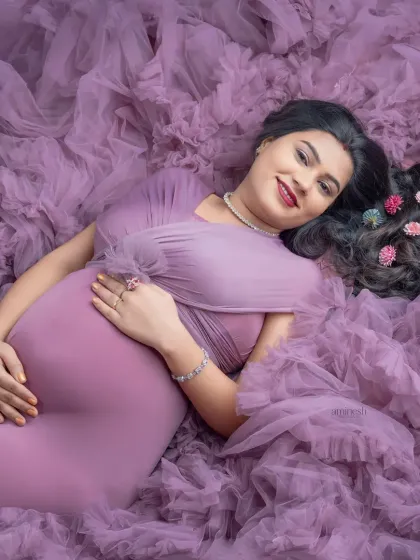 A creative overhead shot that uses the gown's voluminous ruffles to create a beautiful, textured bed of fabric. This pose is comfortable, unique, and results in a stunning fine art portrait.