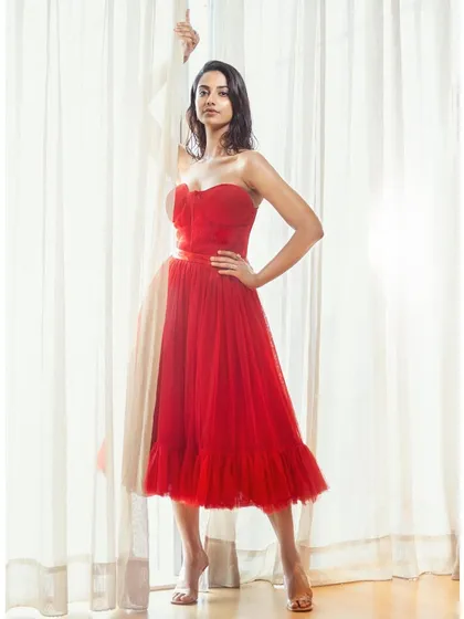 This strapless red tulle dress creates a classic, romantic silhouette. The sweetheart neckline and full skirt are perfect for a celebratory occasion.