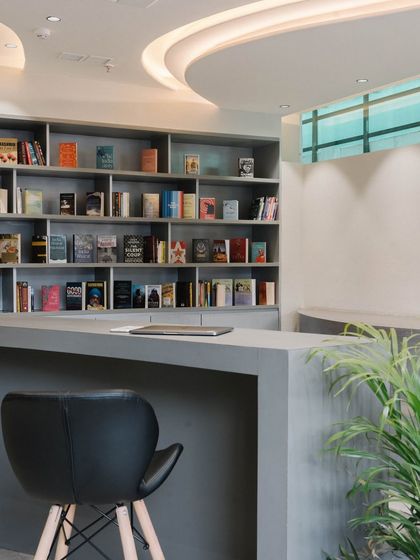 The curved form of the reception desk is echoed in the ceiling design, creating a cohesive and fluid entrance space.