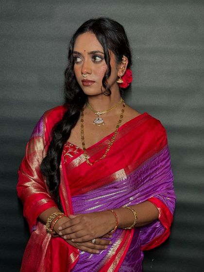 A close-up of the client's traditional look, showing how the simple hairstyle complements her beautiful jewelry and saree.