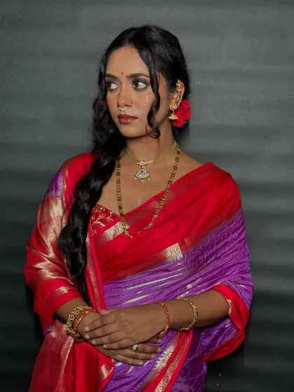 A close-up of the client's traditional look, showing how the simple hairstyle complements her beautiful jewelry and saree.