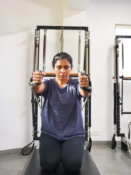 This client demonstrates a chest expansion exercise on the Cadillac, a classic Pilates move that strengthens the back of the arms and shoulders while opening up the chest. It's fantastic for improving posture.