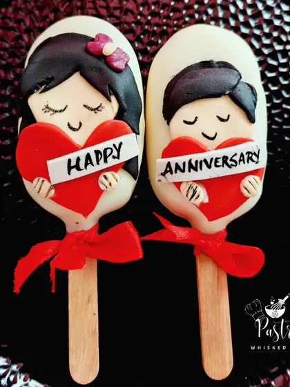 Celebrating love, one bite at a time. These adorable "Happy Anniversary" cakesicles are filled with rich chocolate cake and coated in smooth white chocolate, perfect for surprising your special someone.
