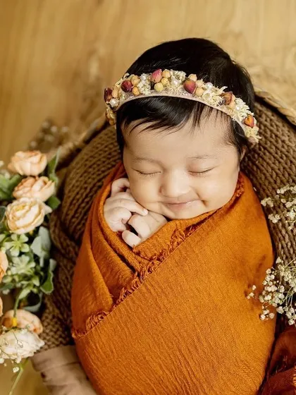 That sleepy newborn smile is just priceless. For my posed newborn sessions, I bring soft wraps, beautiful props, and a lot of patience to capture these peaceful, angelic portraits right in your home.