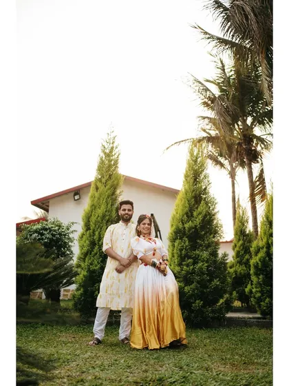 A classic portrait of the couple on their Haldi day. Their happy smiles and the beautiful green surroundings create a fresh and joyful image.