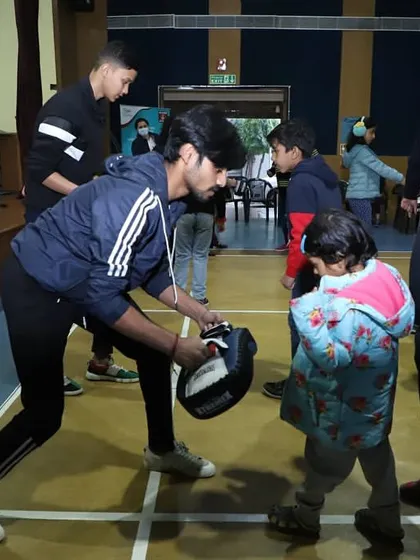 Even our youngest students get involved. Here, an instructor patiently teaches a young child the basics of striking.