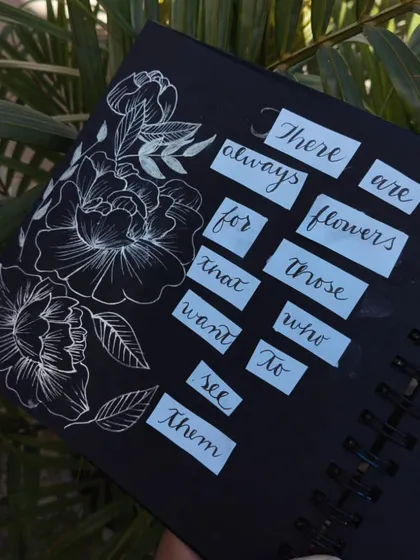 A quote in my black paper journal: "There are always flowers for those who want to see them," illustrated with white ink flowers.