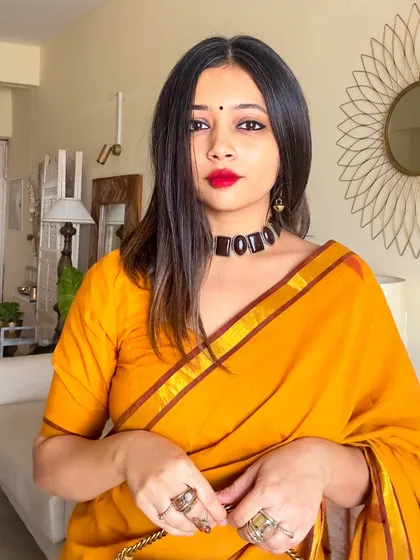 A close-up portrait showing the flattering neckline of the blouse and the bold red lip that contrasts beautifully with the yellow saree.