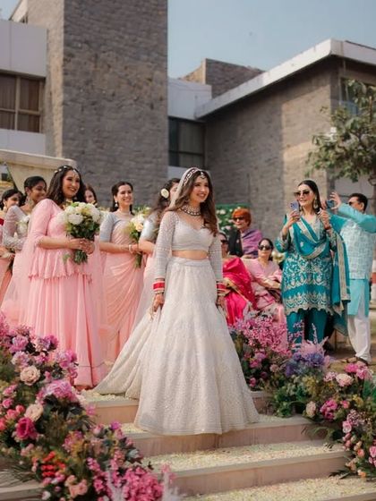 The bride's grand entrance, walking down a staircase lined with flowers with her bridesmaids. This is a key moment that I always ensure to capture from the best angle.