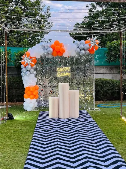 The complete daytime view of the outdoor shimmer wall decoration. The silver sequins sparkle even in natural light, creating a fantastic photo backdrop for a garden party.