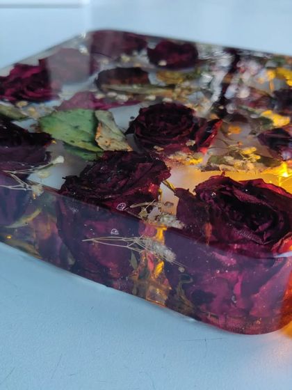 This resin block preserves a client's bouquet of roses, turning them into a permanent piece of art. The wooden base with an LED light makes the flowers glow beautifully.