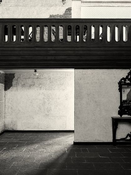 An empty corner of the room, where light and shadow play across the stone floor. The design uses negative space to create a sense of calm.