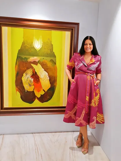At an art gallery opening in a beautiful printed dress. The colors in the dress echo the colors in the artwork, creating a harmonious connection.